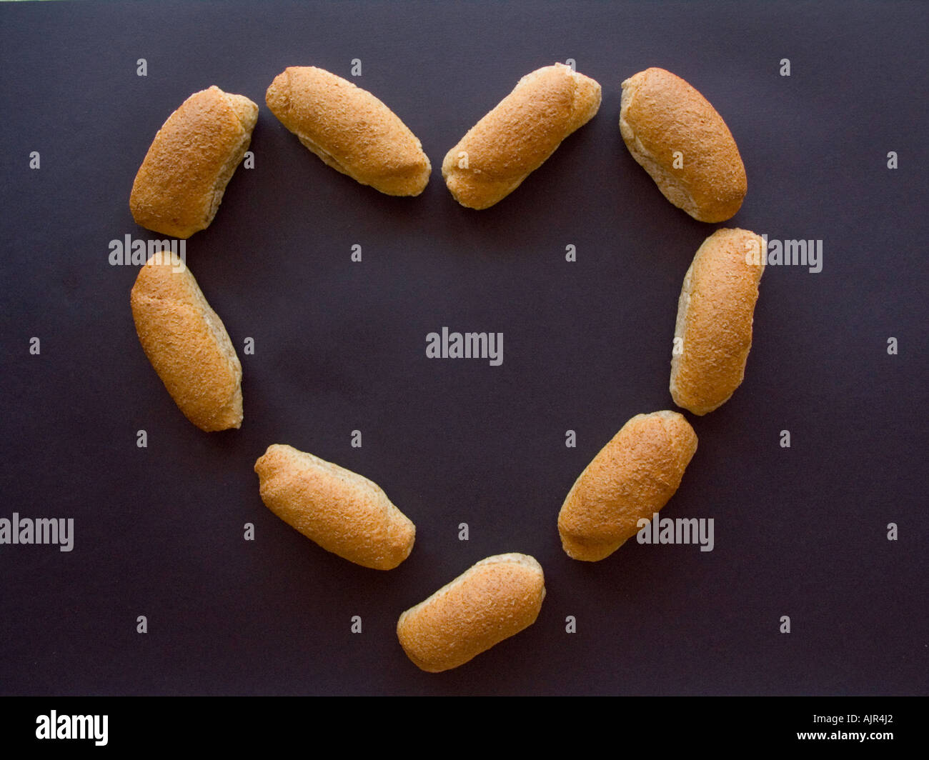 Composizione di differenti tipi di pane - bun baguette - arrangend in un cuore di amore Foto Stock