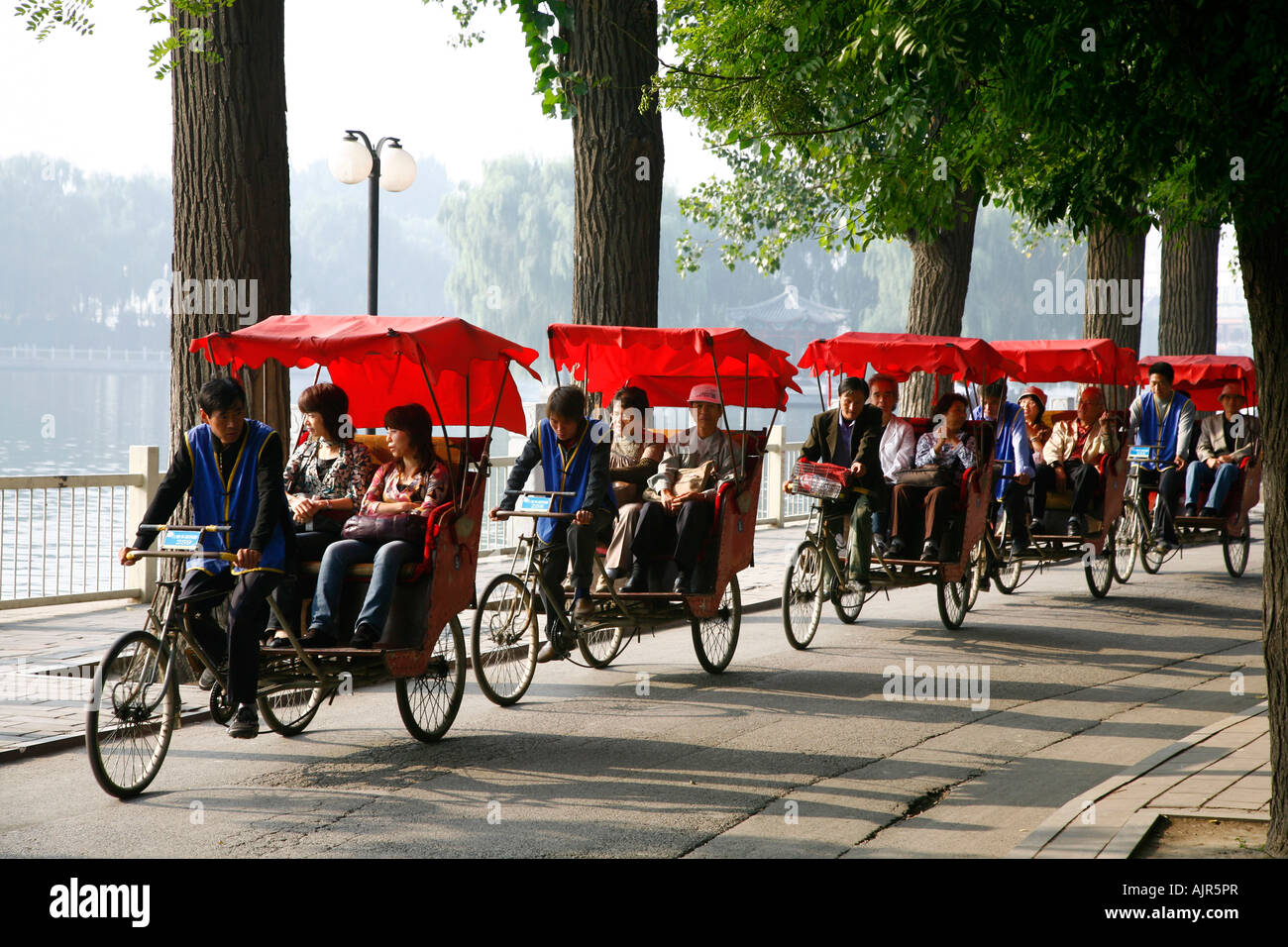 In rickshaw driver di turisti in un tour in l'Houhai area dei laghi di Pechino CINA Foto Stock