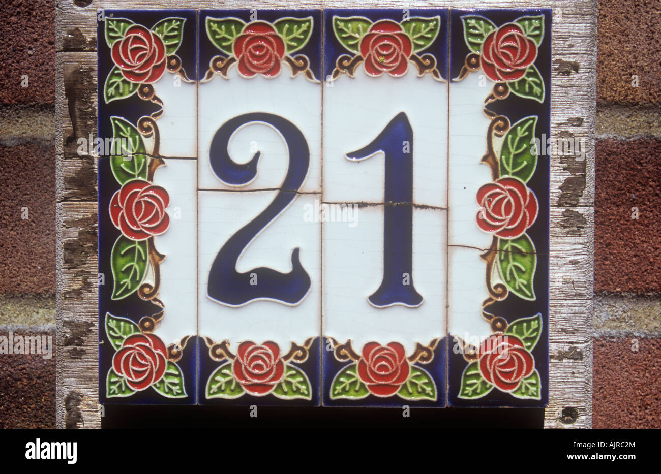 Vicino di casa numero di piastrelle indicando 21 decorate in British movimento Arts and Crafts stile ma con ogni piastrella incrinato Foto Stock