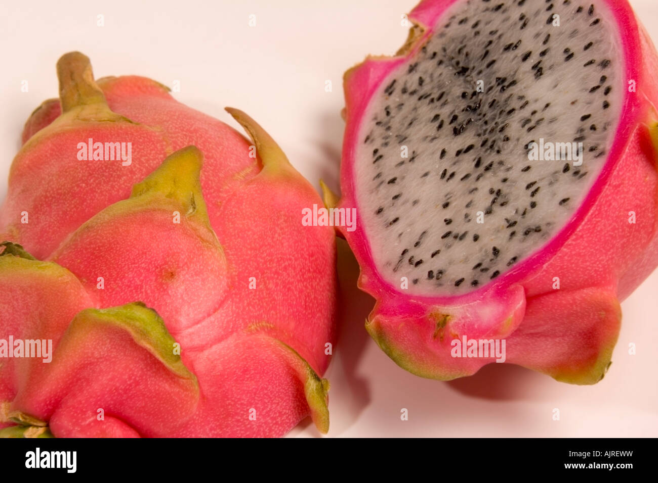 Drago maturo frutta, Hylocereus undatus, tagliato a metà per mostrare la carne bianca e semi Foto Stock