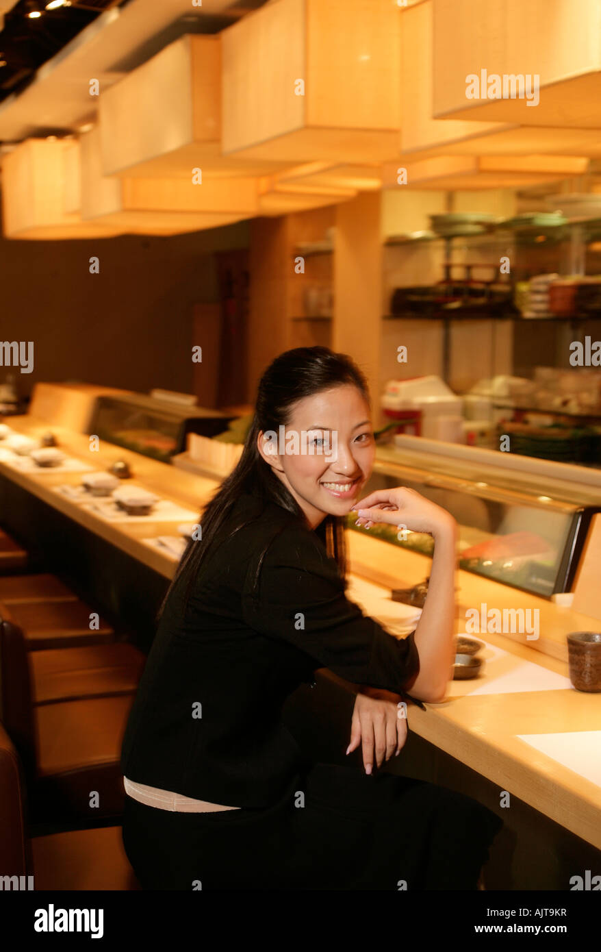 Ritratto di una imprenditrice seduta in una caffetteria counter Foto Stock