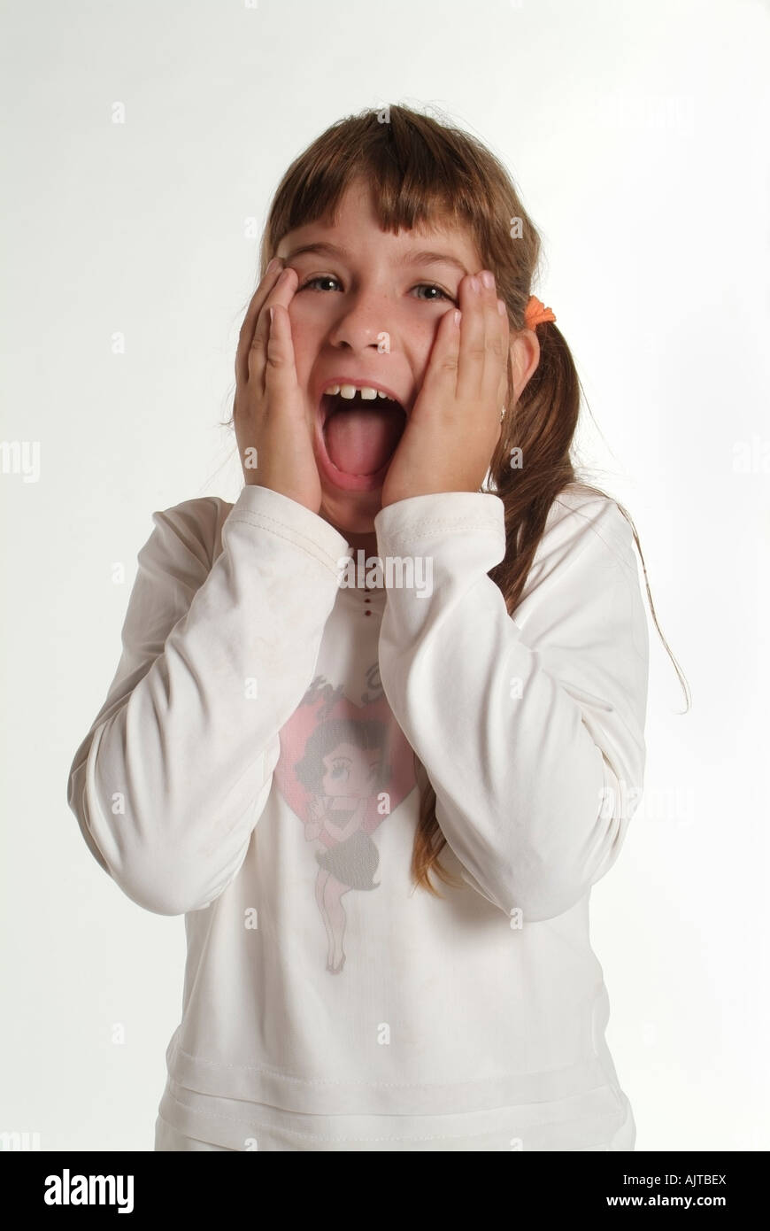 Ritratto in studio di un California preteen ragazza ridere con le sue mani per il suo volto Foto Stock