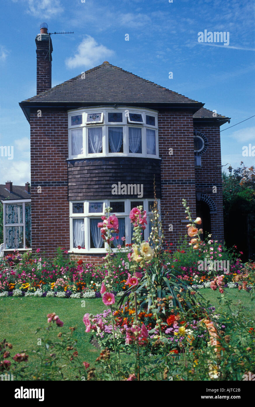 Evercreech Somerset Inghilterra 1920s 30s casa indipendente di mattone con estate front fiori da giardino prato ovest paese Foto Stock