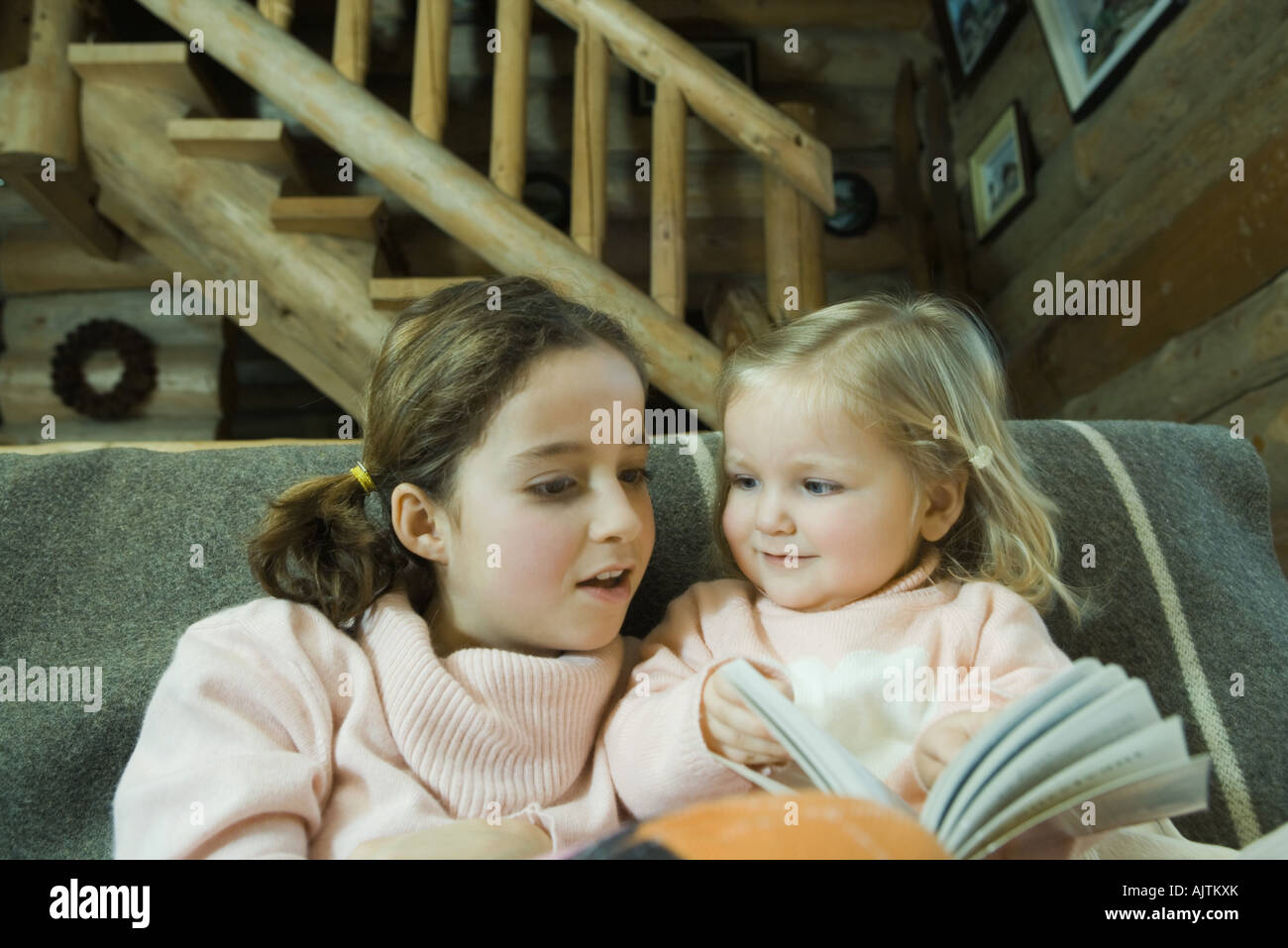 Preteen lettura della ragazza prenota con bambino Foto Stock