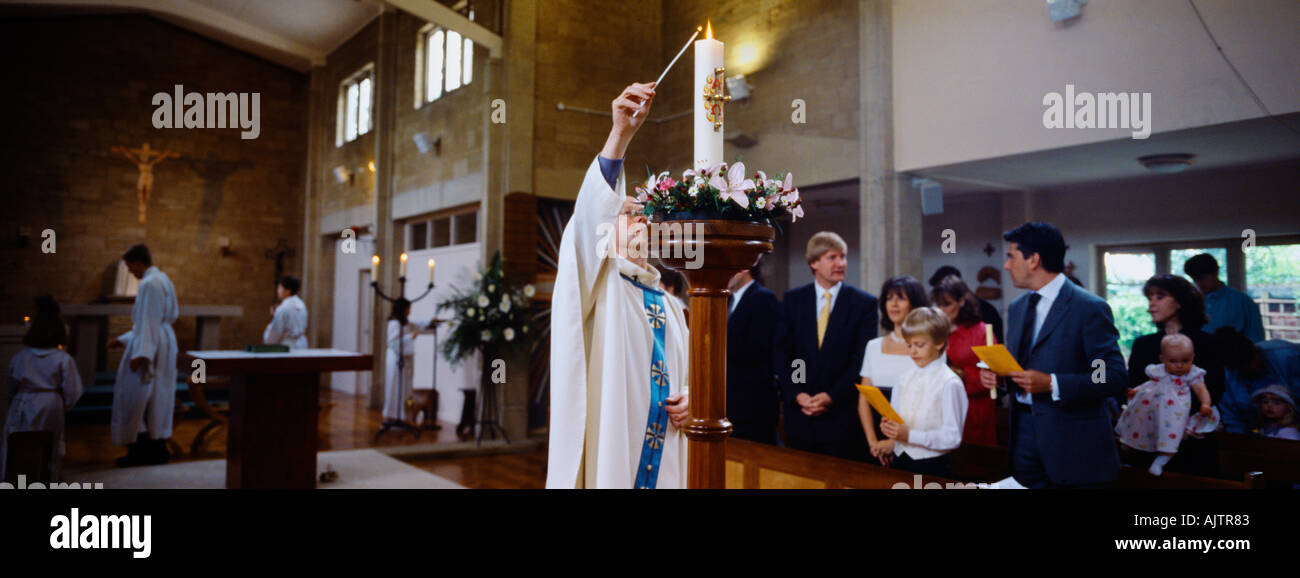 Prima Comunione sacerdote illuminazione Cero Pasquale St Bernard s Chiesa Sussex England Foto Stock