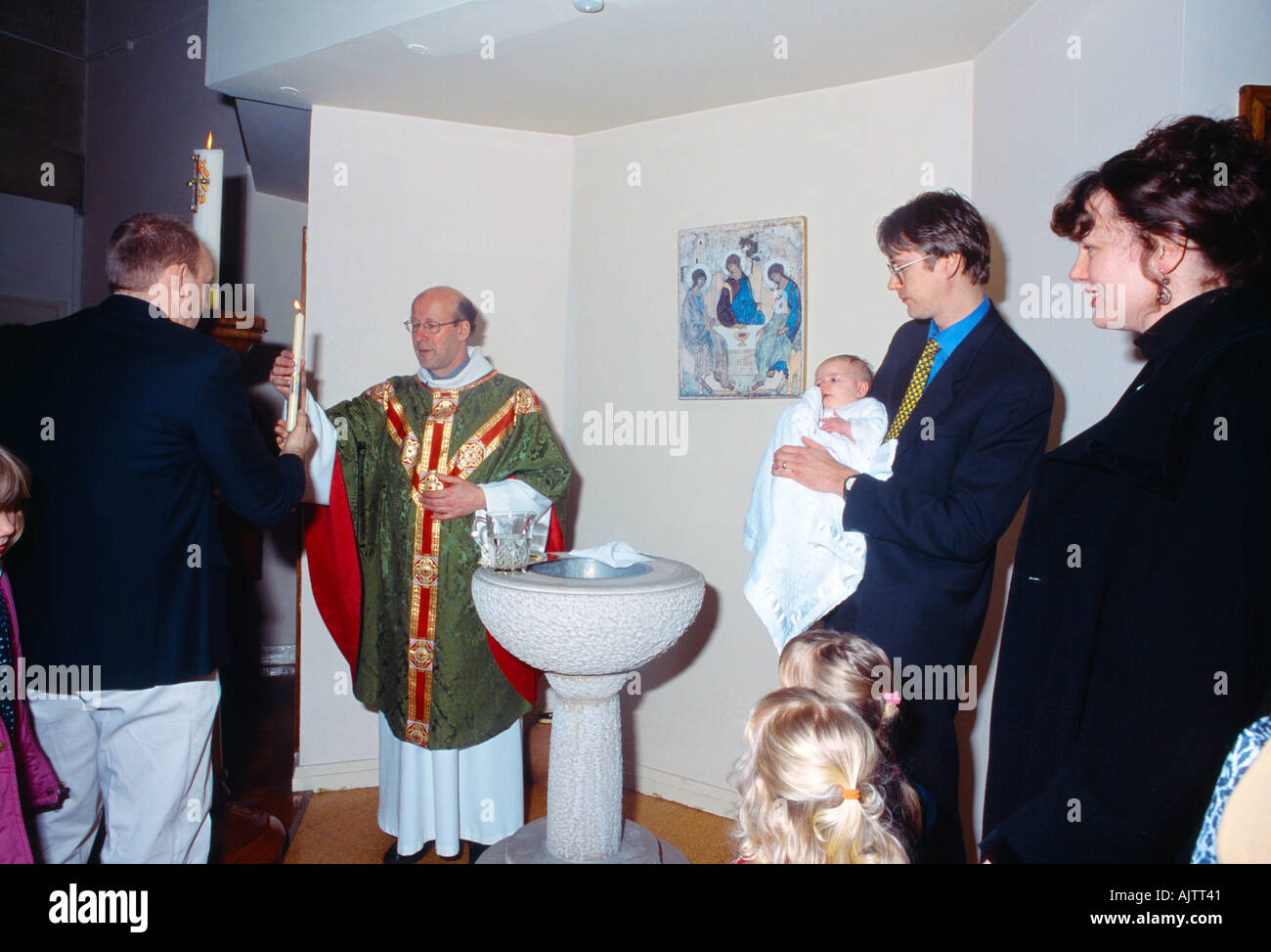 San Bernardo s chiesa cattolica padrino consegna illuminato cero pasquale al sacerdote Battesimo Lingfield Foto Stock