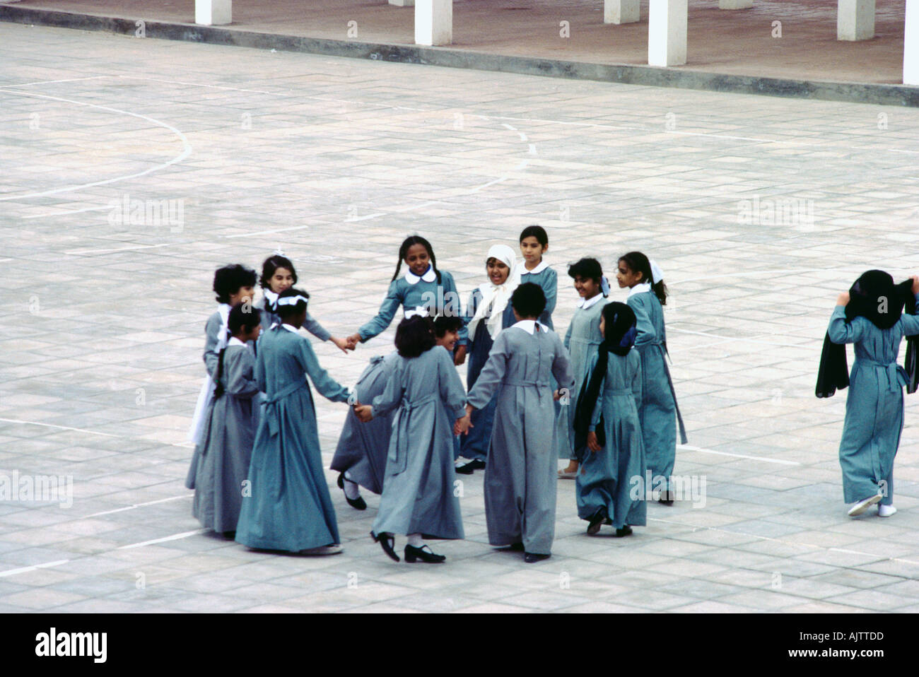 Abu Dhabi Emirati arabi musulmani ragazze della scuola nel parco giochi tenendo le mani in un cerchio alcuni indossano il velo Foto Stock