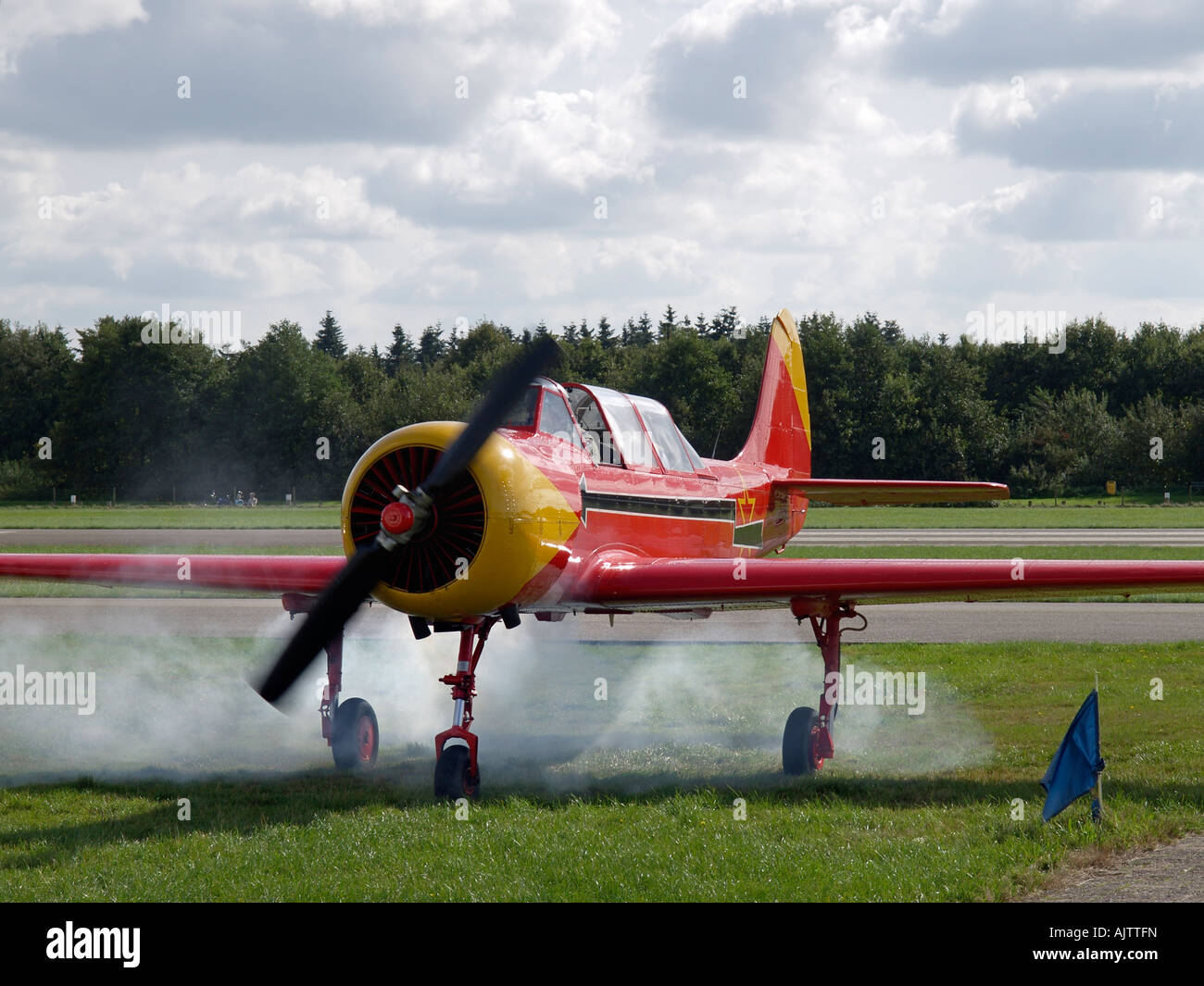 A partire classic yakovlev yak 52 aereo in una nuvola di fumo di olio che presumibilmente è normale aviosuperficie seppe nei Paesi Bassi Foto Stock