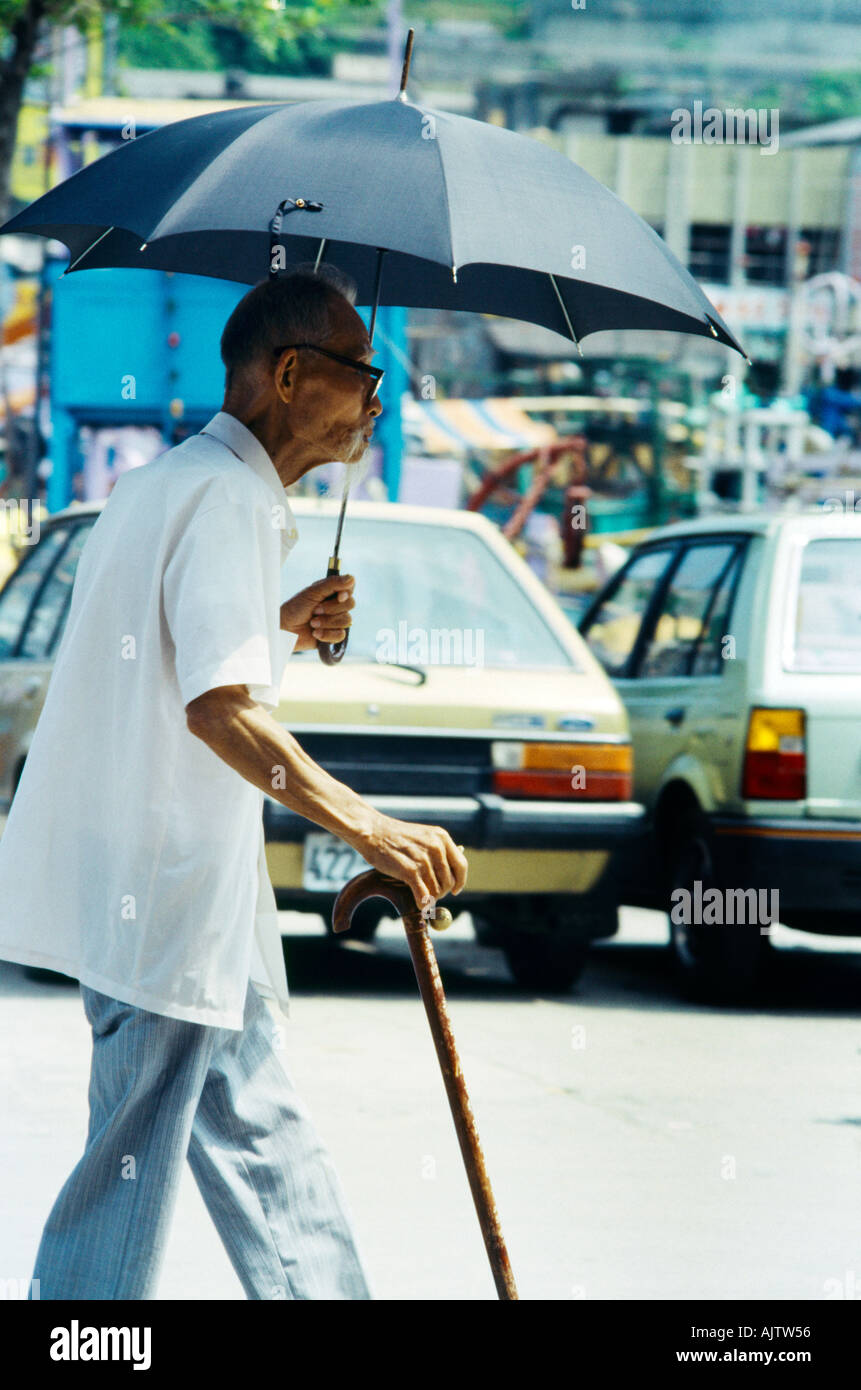 Suao Taiwan uomo anziano con ombrellone bastone da passeggio Foto Stock