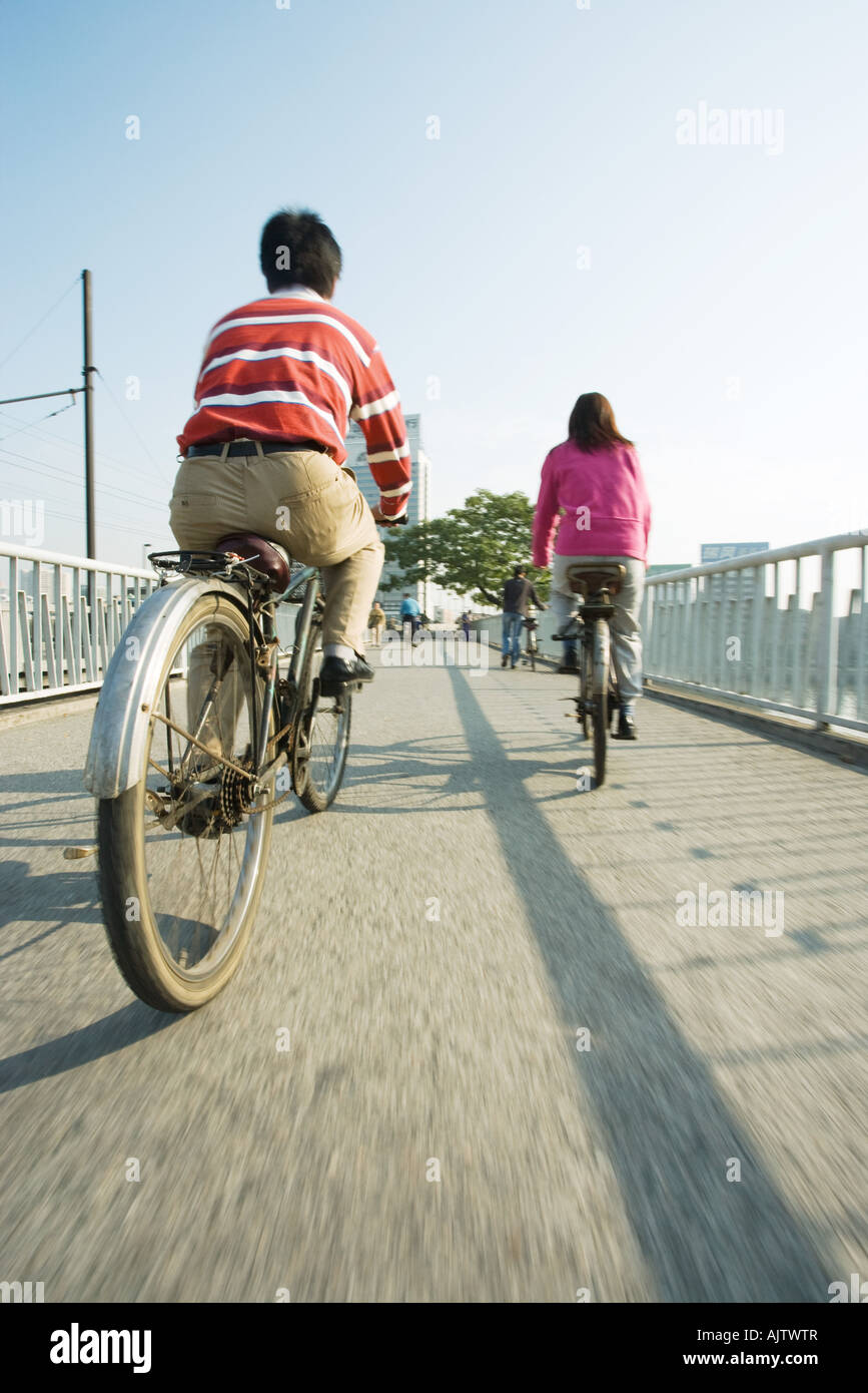 I ciclisti attraversando il ponte, vista posteriore Foto Stock