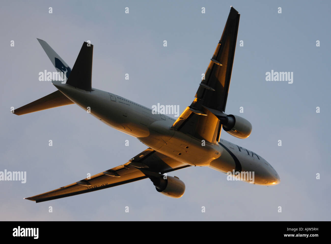 Pakistan International Airlines PIA Boeing Boeing 777 appena dopo il decollo nel riflettere la luce del tramonto all'aeroporto di Heathrow, Londra Foto Stock