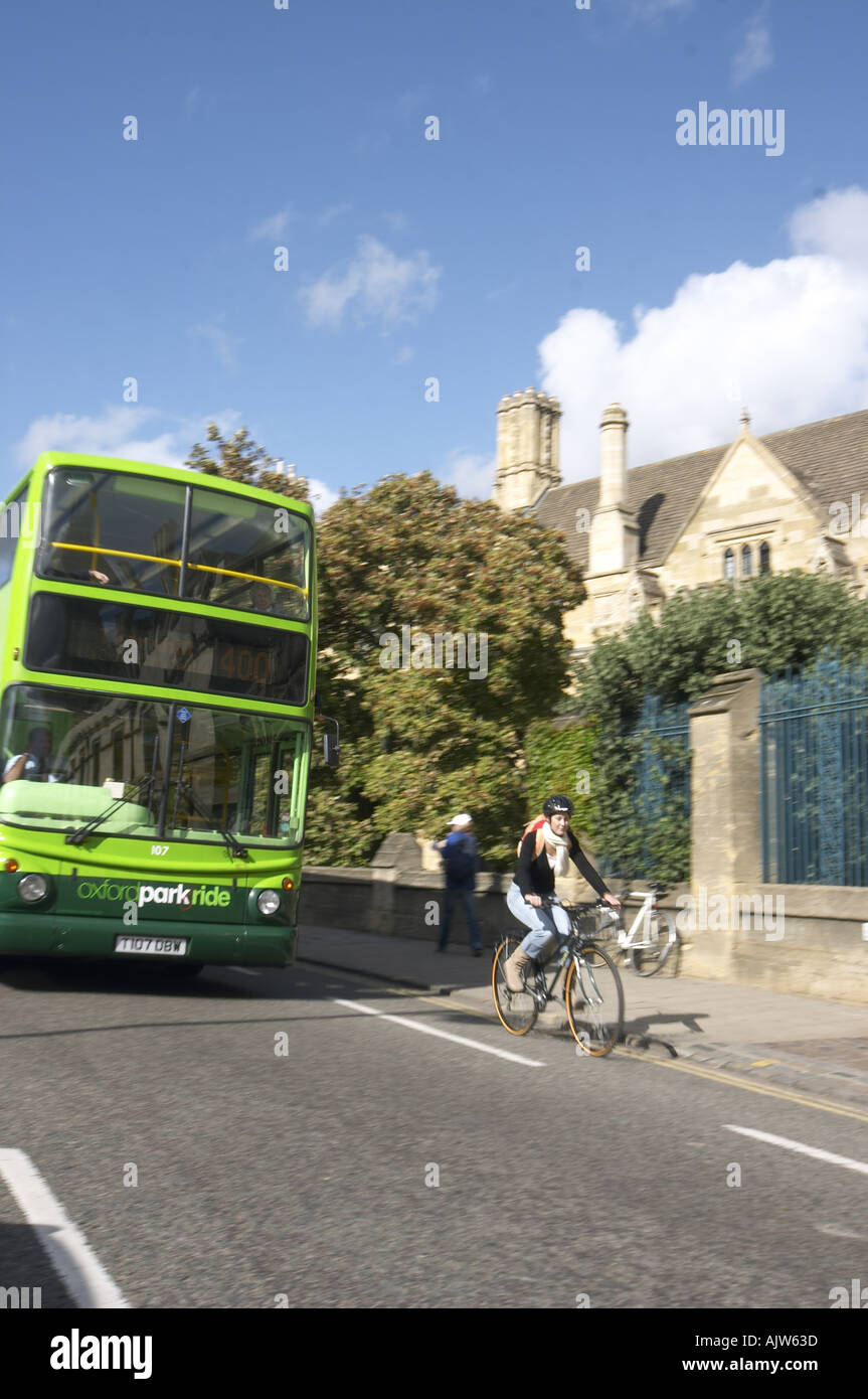 Ragazza su una bicicletta e verde bus Oxford Oxford Inghilterra 2004 Foto Stock