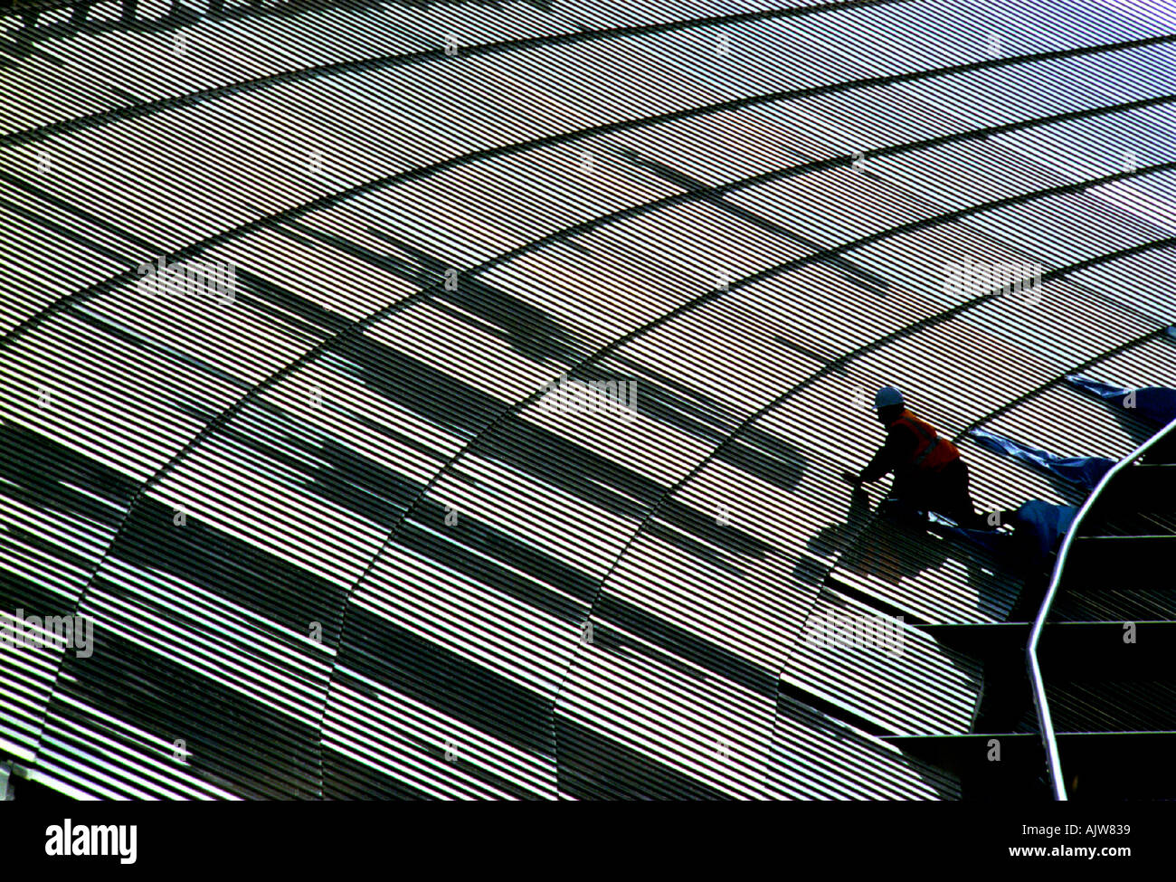 Workman in hard hat fino all'enorme Victorian span di stazioni di Brighton tetto di vetro Foto Stock