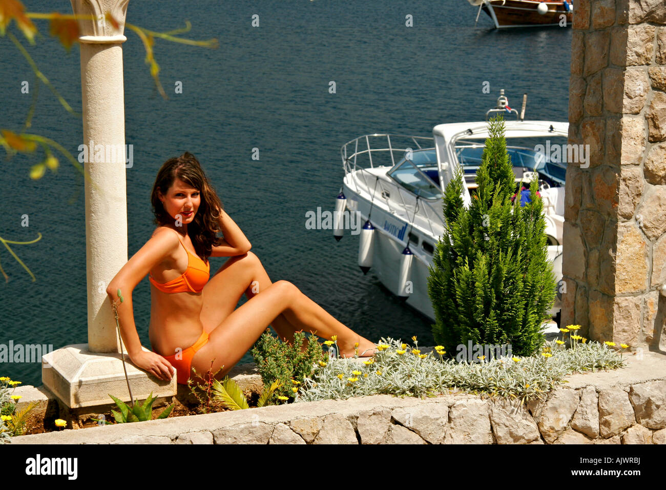 Junge Frau sonnt sich an der Kroatischen Mittelmeerkueste | giovane donna è prendere il sole presso il croato costa Mediterranea Foto Stock