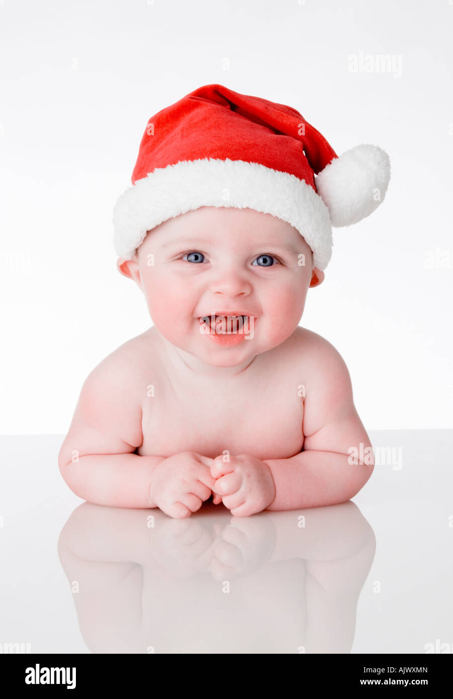 Formato ritratto foto di un simpatico bella Laughing baby indossando una Santa Babbo Natale hat su un bianco sullo sfondo di perspex Foto Stock