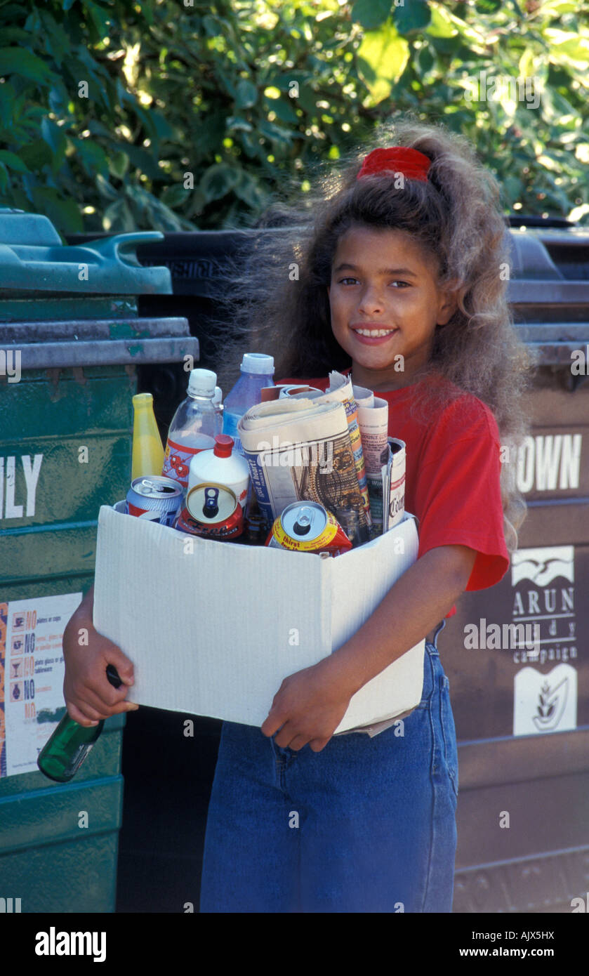 Giovane ragazza scatola di trasporto di rifiuti riciclabili a scomparti di riciclaggio Foto Stock
