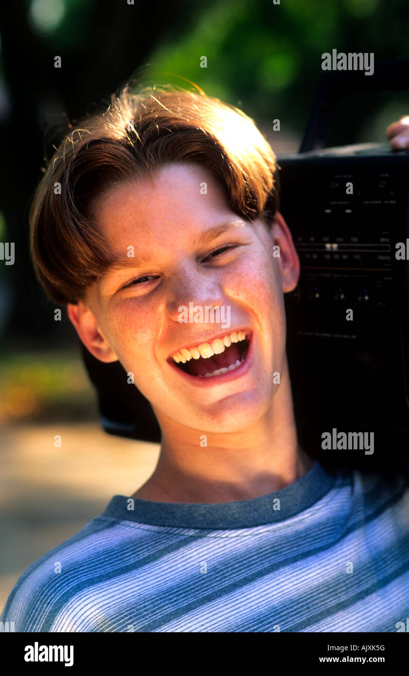 Adolescente anziano 13 radio in riproduzione forte da boom box e sorridente Foto Stock