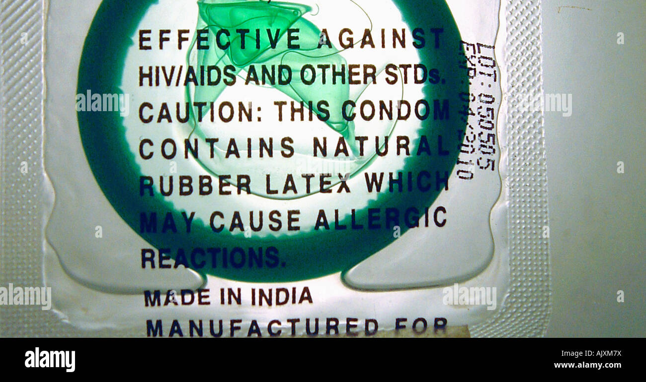 Closeup Still Life fotografia di un verde condom in lattice in un contenitore trasparente Foto Stock