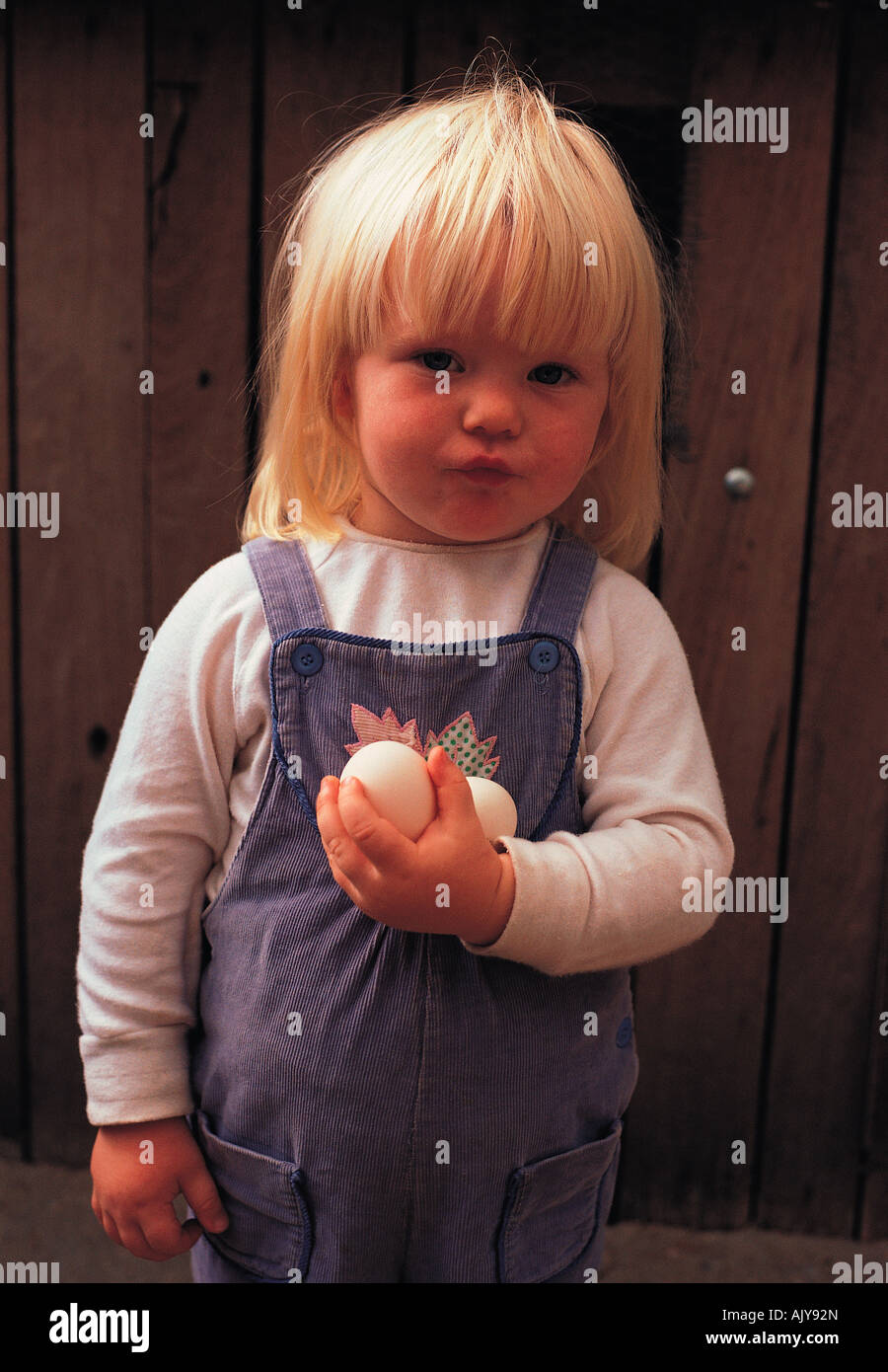 I bambini. Ritratto di bimba bionda azienda nuova posa di gallina uova Foto  stock - Alamy