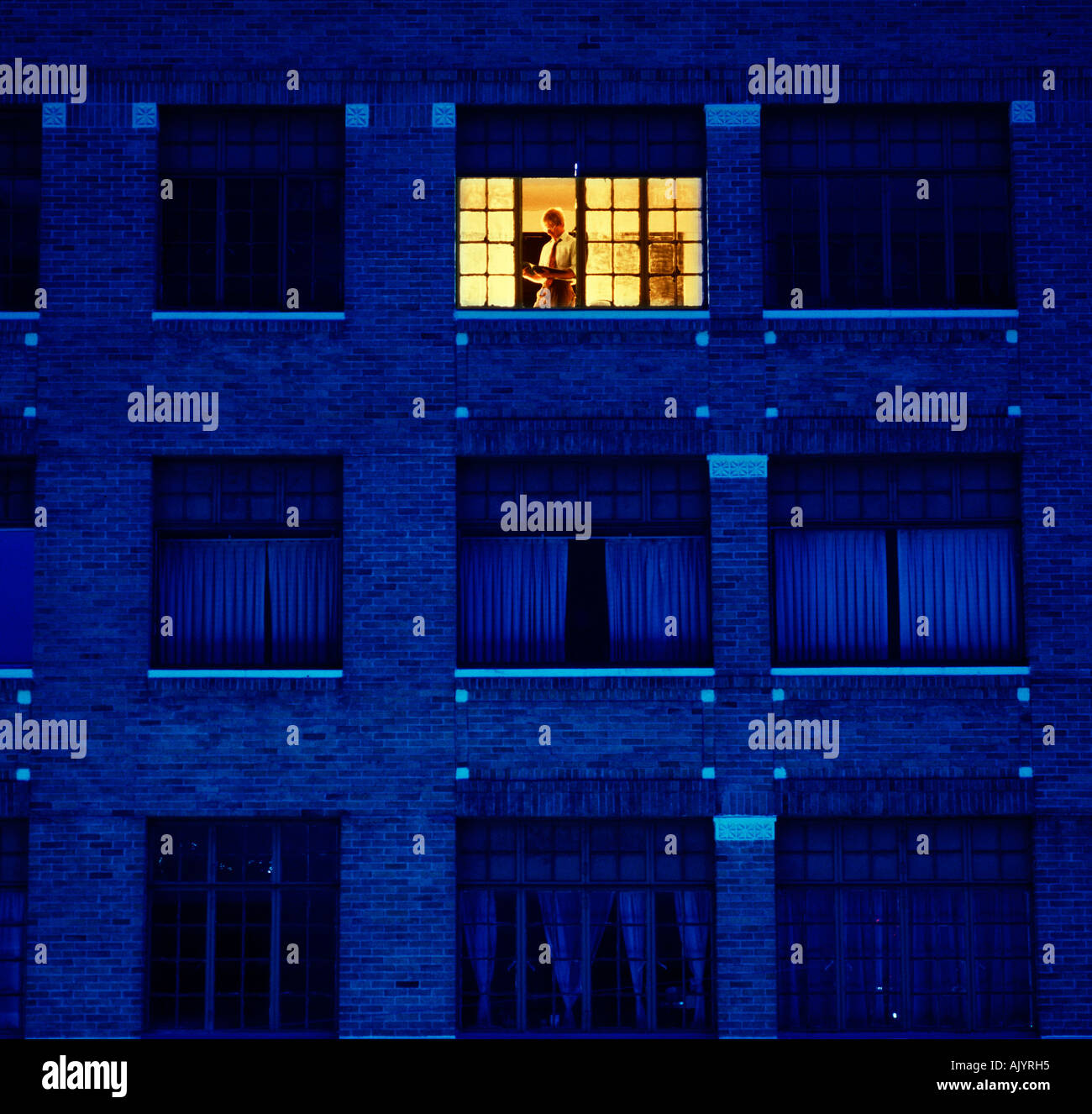 Maschio lavoro esecutivo a tarda notte in edificio per uffici Foto Stock