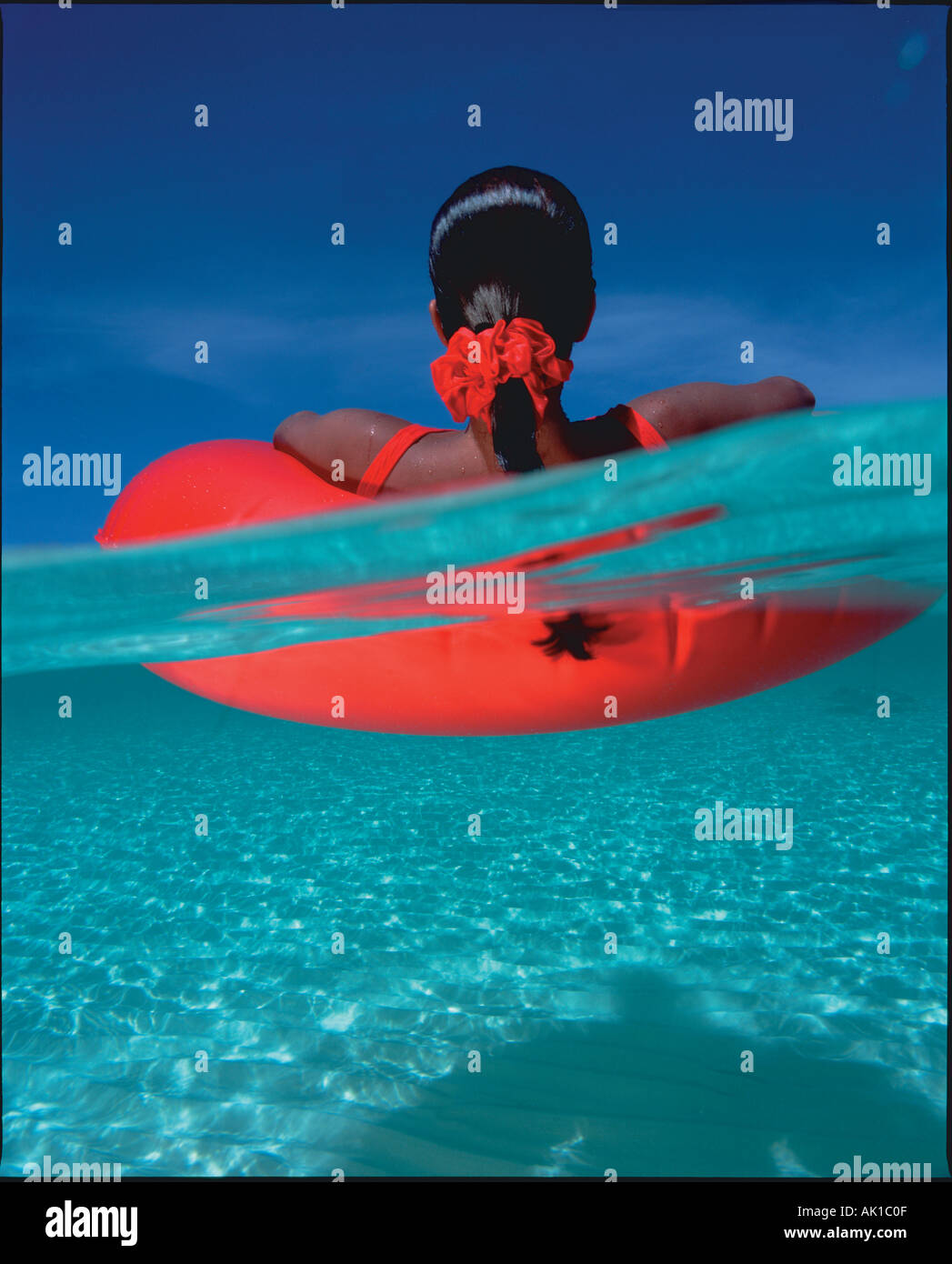 Grand Cayman Sandbar sotto su Donna galleggia sul rosso tubo inter Foto Stock