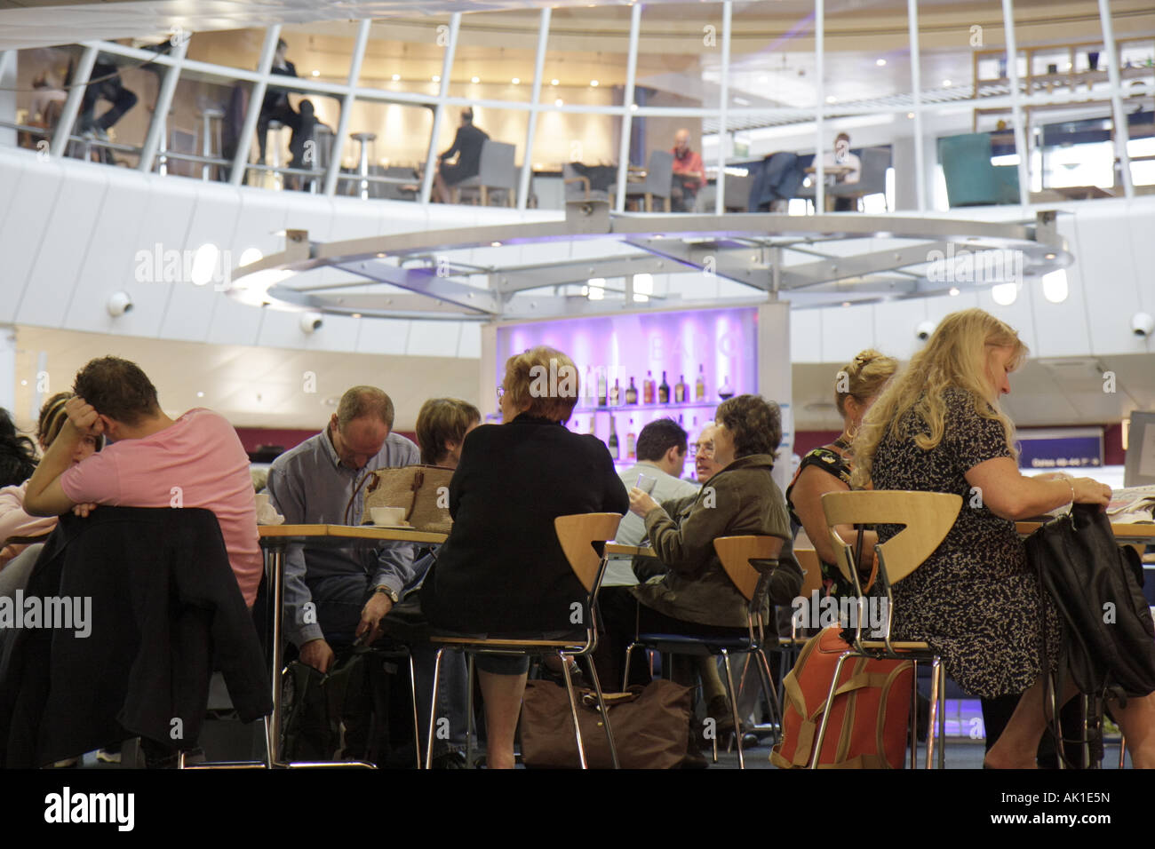 Inghilterra Regno Unito Regno Unito, Gran Bretagna Inglese britannico, Lancashire, Manchester, Aeroporto di Manchester, gate, passeggeri in partenza, tavoli, visitatori viaggio su una strada Foto Stock