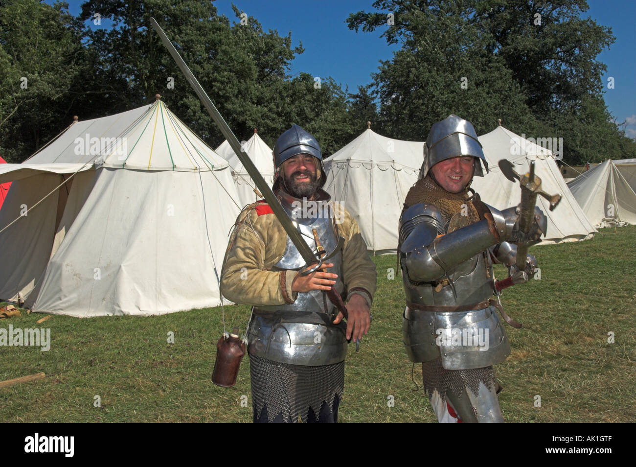 Due uomini in abiti di armatura scintillante una holding pike altri di una cotica erbosa alla rievocazione medievale Foto Stock