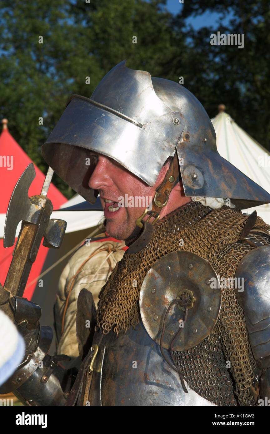 Primo piano di uomo in tuta di armatura scintillante tenendo il luccio alla rievocazione medievale Foto Stock