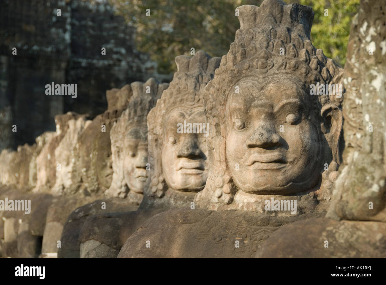 Il demone di pietra si affaccia sul ponte naga presso la porta sud di Angkor Thom Angkor Seam Reap Cambogia Foto Stock