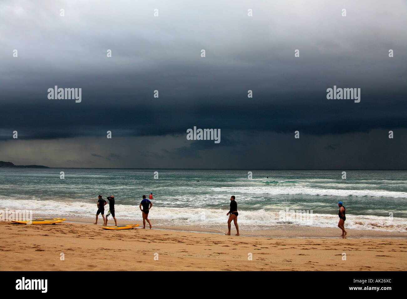 Persone e nuvole temporalesche della costa a Manly Beach Sydney Australia Foto Stock
