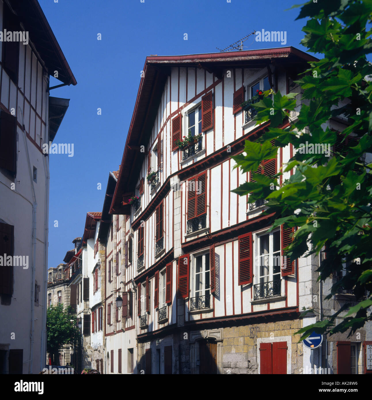Tradizionale architettura basca di case bianche con terracotta persiane colorate in St Jean de Luz Francia Foto Stock