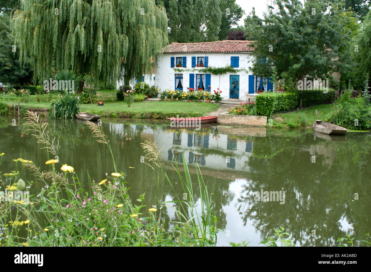 Pittoresca casa sul fiume Sevre, Coulon, Marais Poitevin, Poitou Charentes, Francia Foto Stock