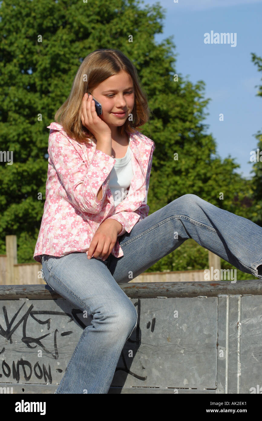Ragazza giovane con telefono cellulare in skate park Foto Stock