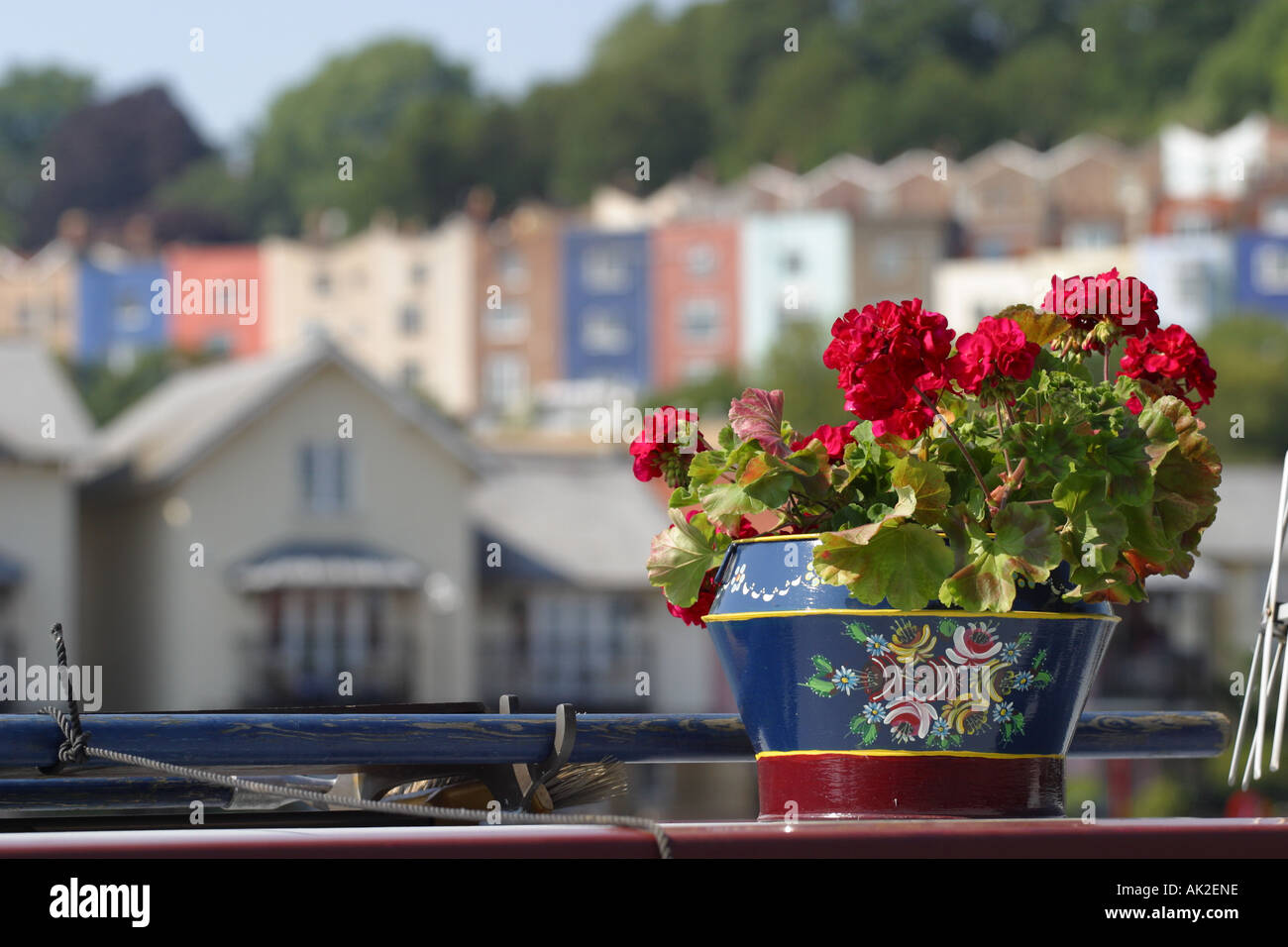 Bristol Inghilterra geranio fiori in vaso dipinta sulla parte superiore del canale barca lungo il tetto con il quartiere Hotwells dietro Foto Stock