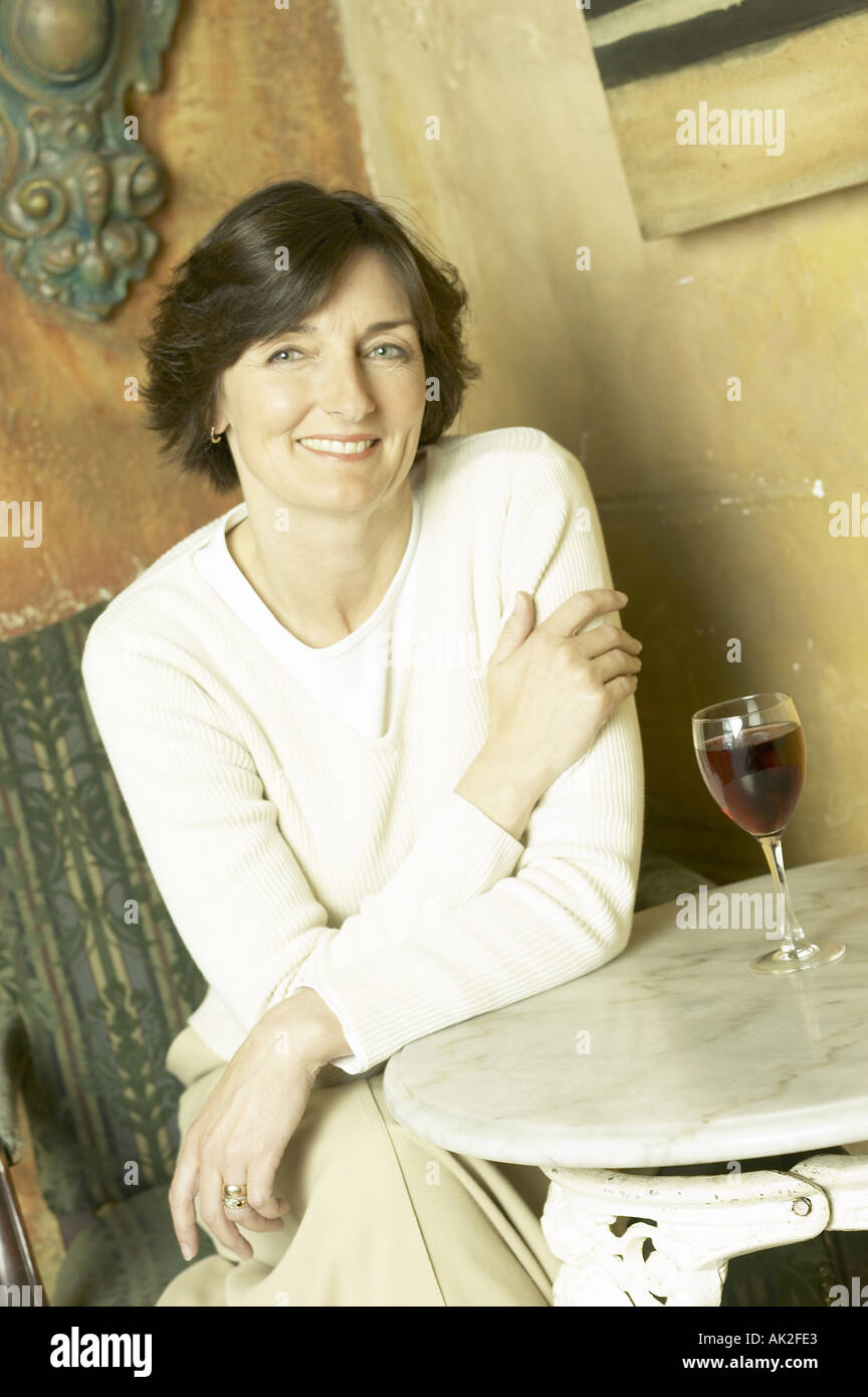 Donna sorridente di bere un bicchiere di vino rosso Foto Stock