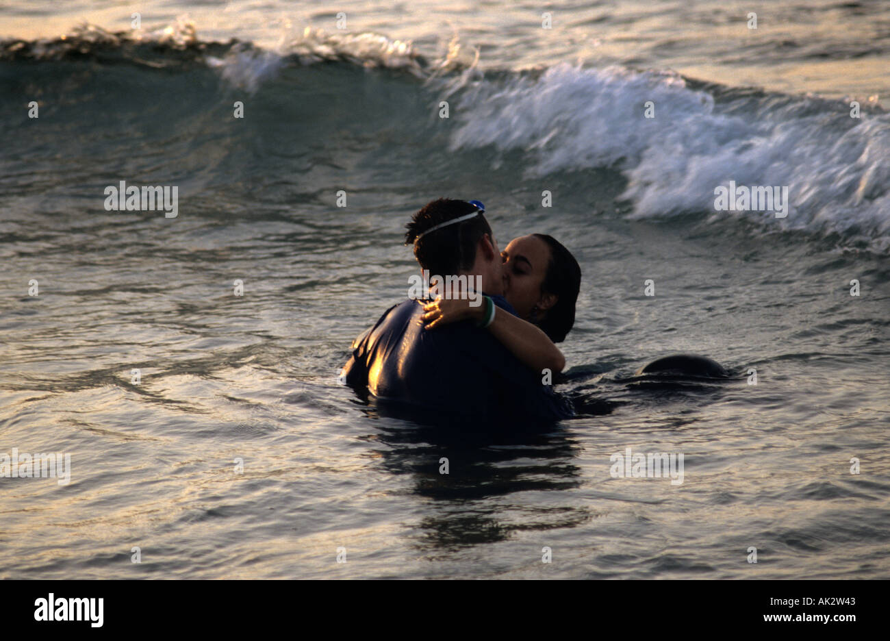 Coppia giovane baciare in mare (sulla spiaggia), tra le onde, Mori e Cristiani festival sbarcherà a Villajoyosa. Costa Blanca Foto Stock