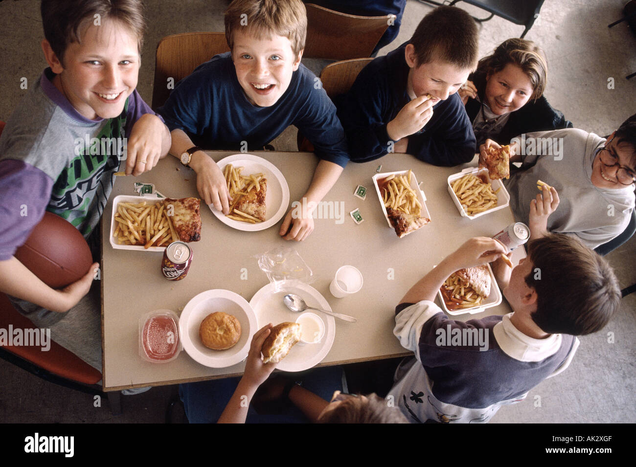 Scuola secondaria mensa caffetteria ragazzo di mangiare a pranzo Foto Stock