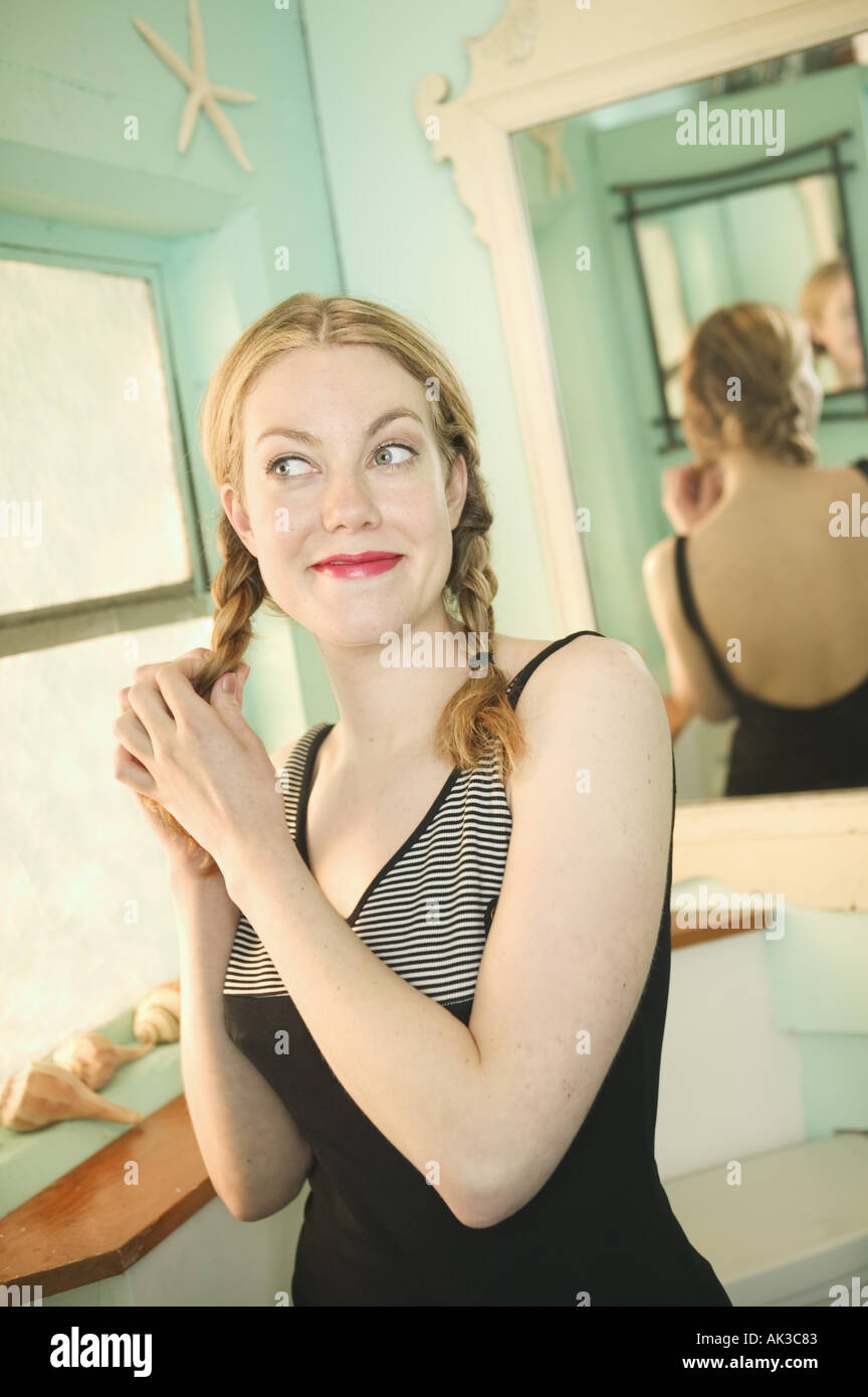 Donna bionda lavorando su una spiralina nel suo bagno Foto Stock