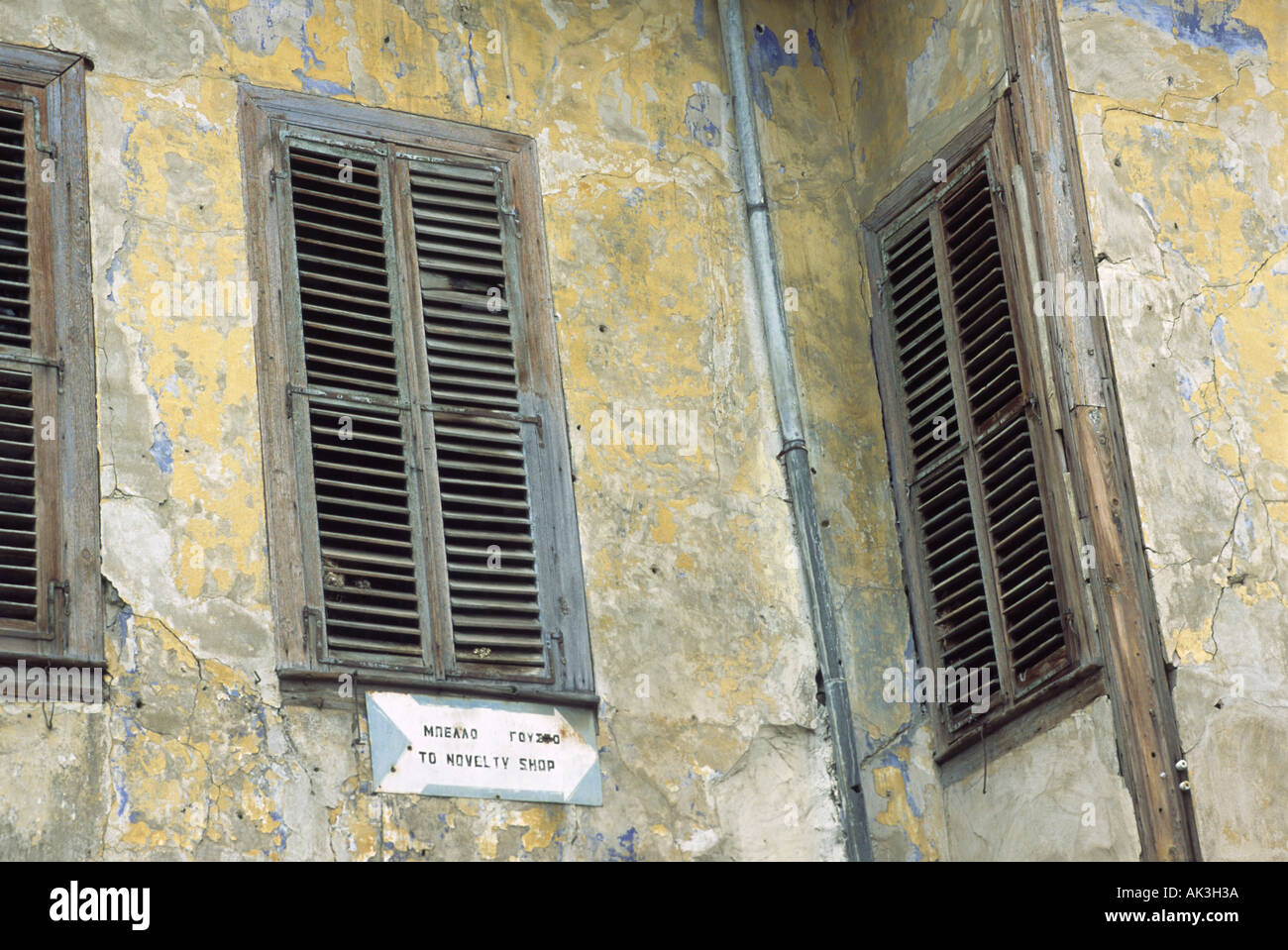 Finestre con persiane su ex Grand House vicino al Greco turco zona di frontiera in Nicosia noto anche come Lefkosia Cipro con Wal Foto Stock