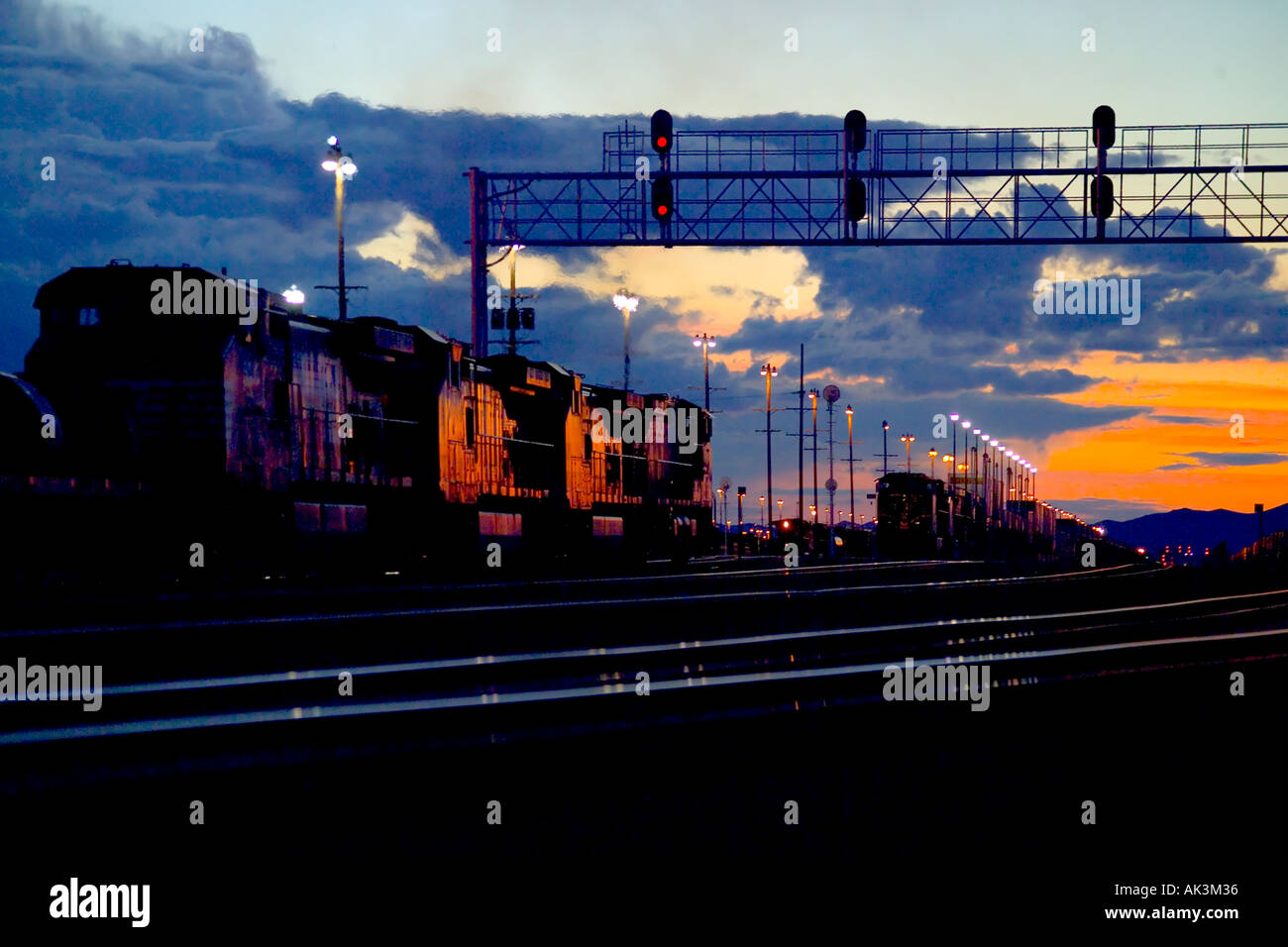 Che riflette il sole di setting una direzione sud treno merci rotoli attraverso Barstow California USA Foto Stock