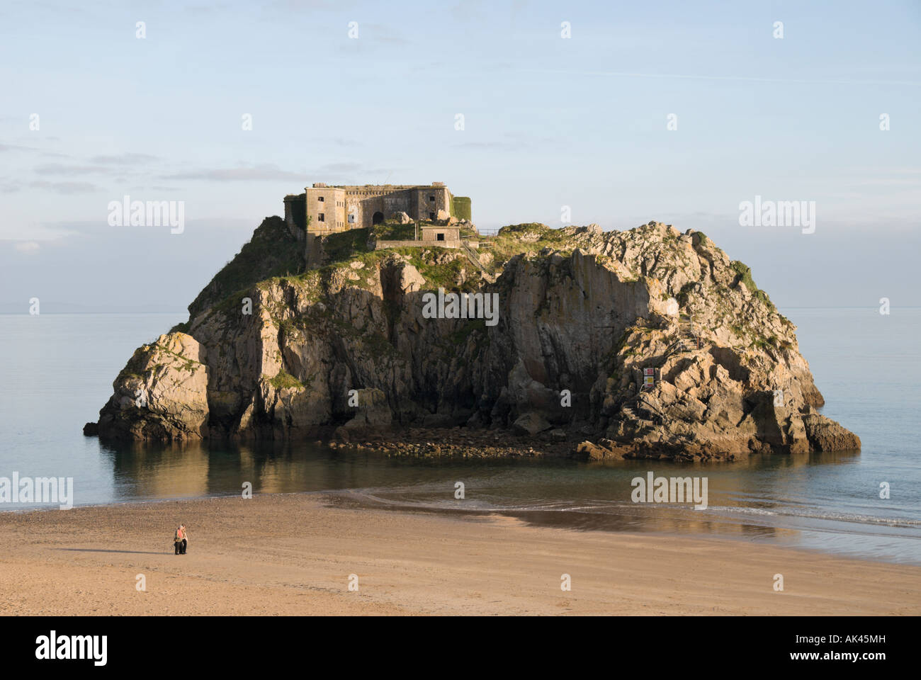 Santa Caterina, Fort St Catherine's Island, Tenby, Pembrokeshire, Wales, Regno Unito. Un paio di persone stanno camminando sulla spiaggia. Foto Stock
