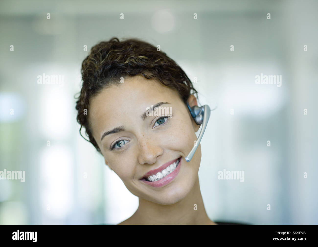 Donna che indossa la cuffia e sorridente Foto Stock