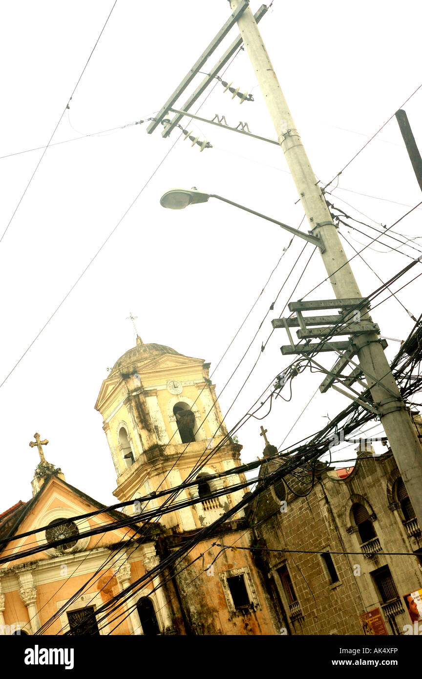 Dirty old chiesa coloniale a Manila nelle Filippine e i cavi telefonici Foto Stock