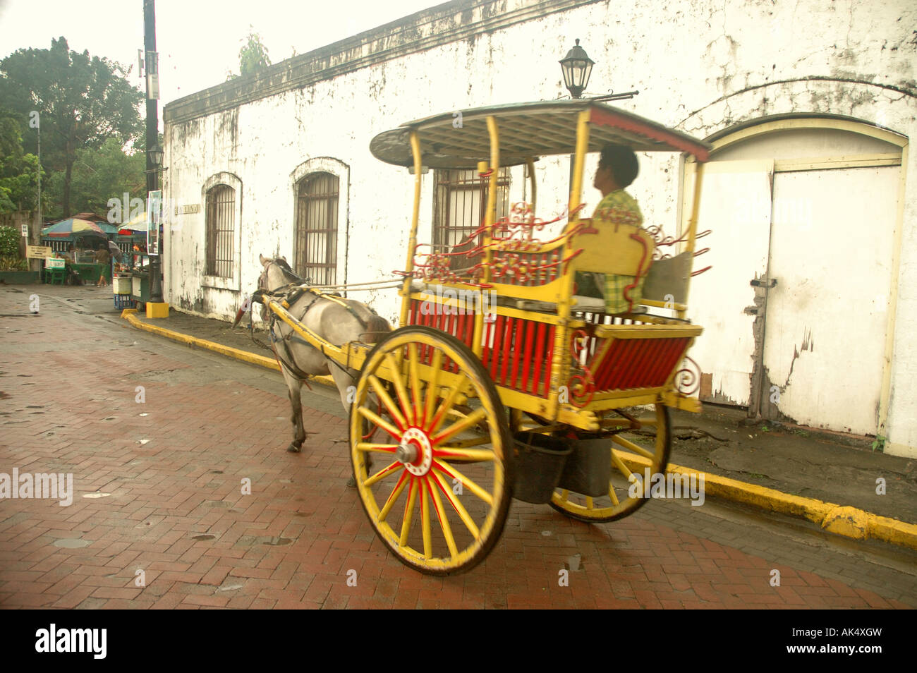 Vecchio cavallo e carrello passante bianco edificio coloniale in Intramuros, Manila Foto Stock