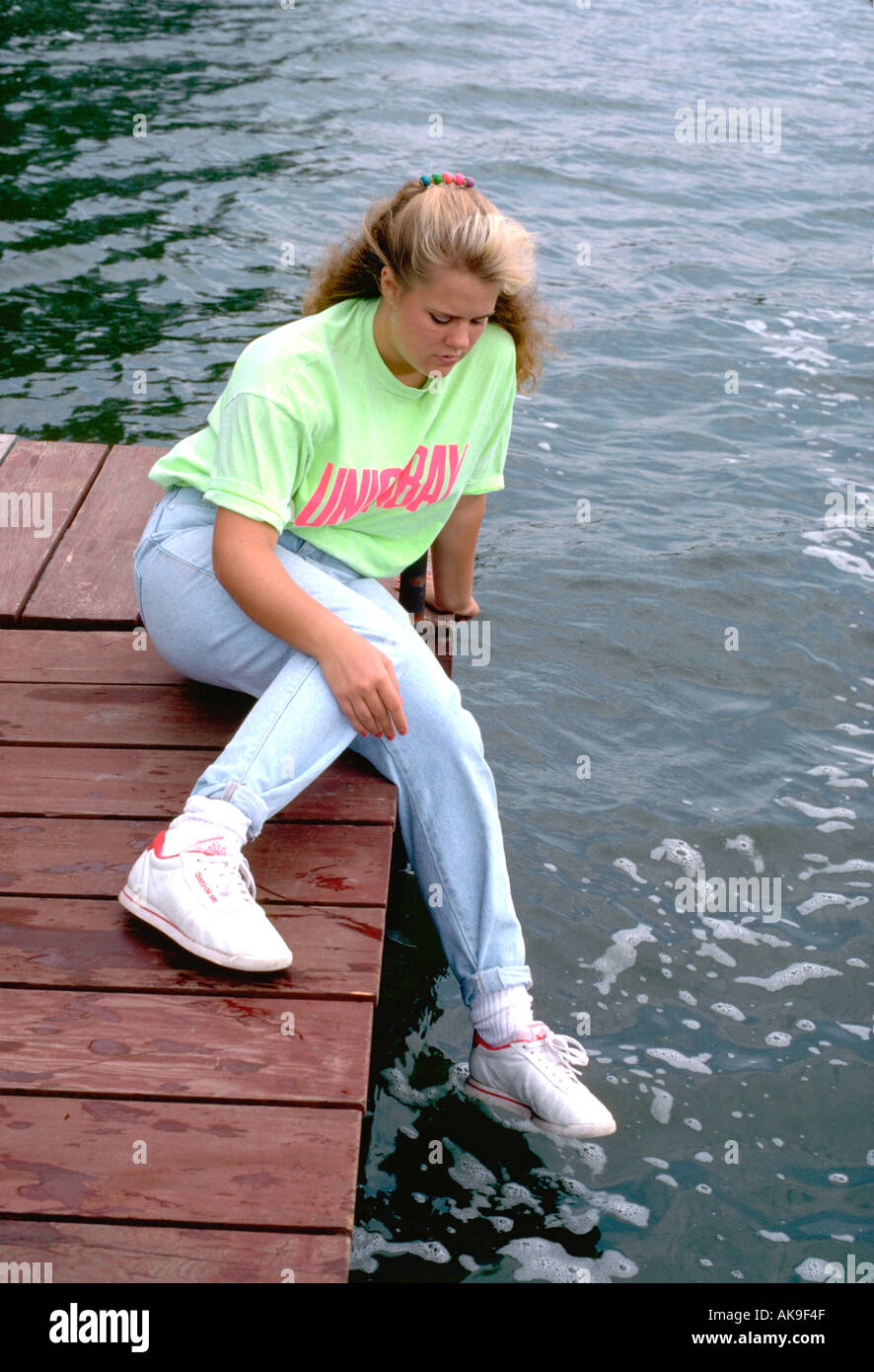 Preoccupato girl età 16 seduto sul dock. Clitherall Minnesota USA Foto Stock