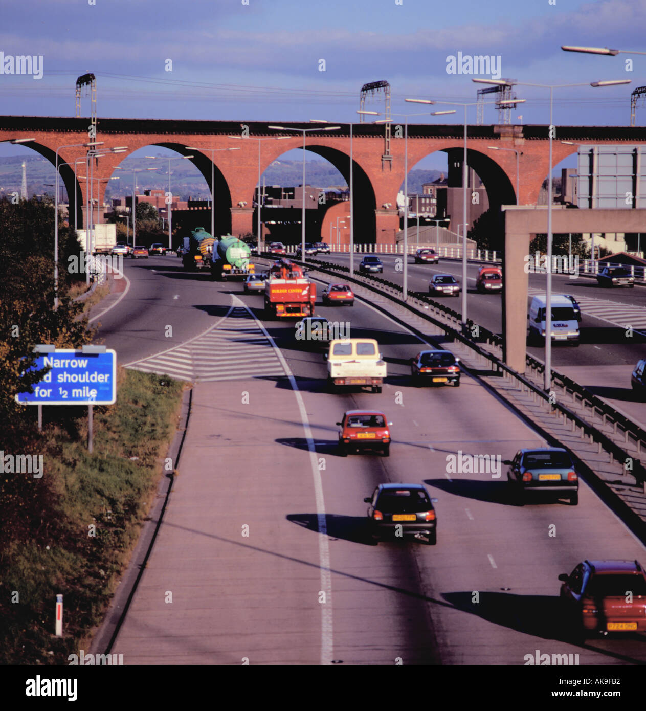 M63 Autostrada passando sotto l'arco in mattoni Mersey viadotto ferroviario, Stockport, Greater Manchester, Inghilterra, Regno Unito. Foto Stock