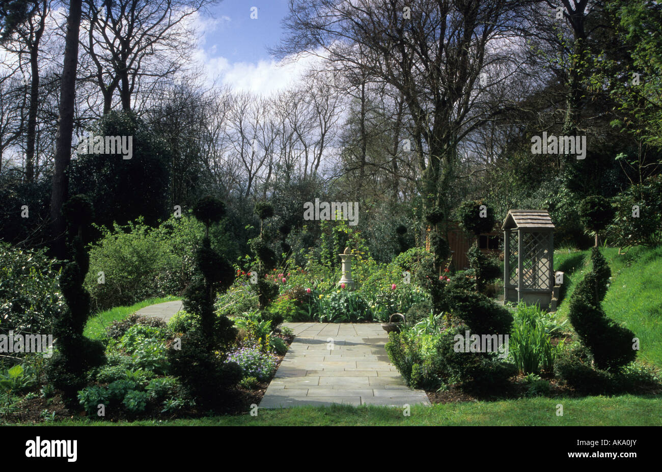 Thursley Lodge Surrey design Fiona Lawrenson giardino formale con spirale yew topiaria da percorsi di ardesia letto circolare Foto Stock