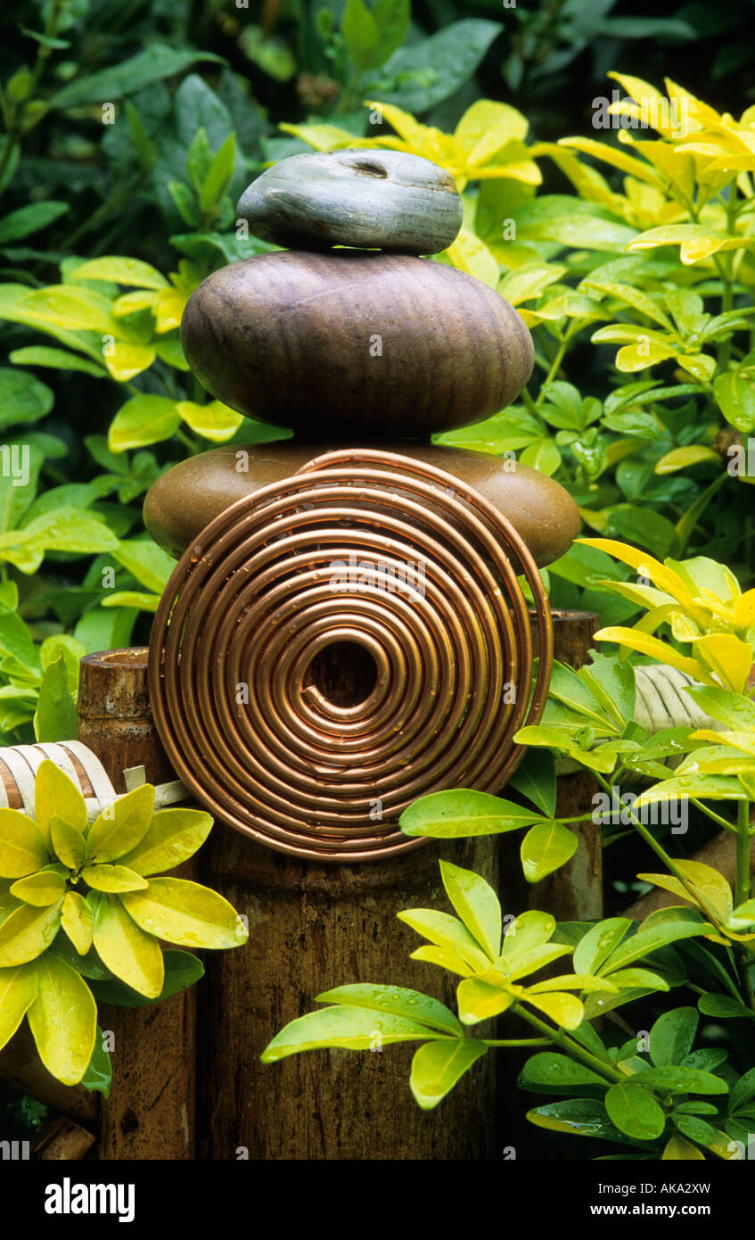 Giardino scultura con bambù post feng shui spirale in rame e ciottoli Foto Stock