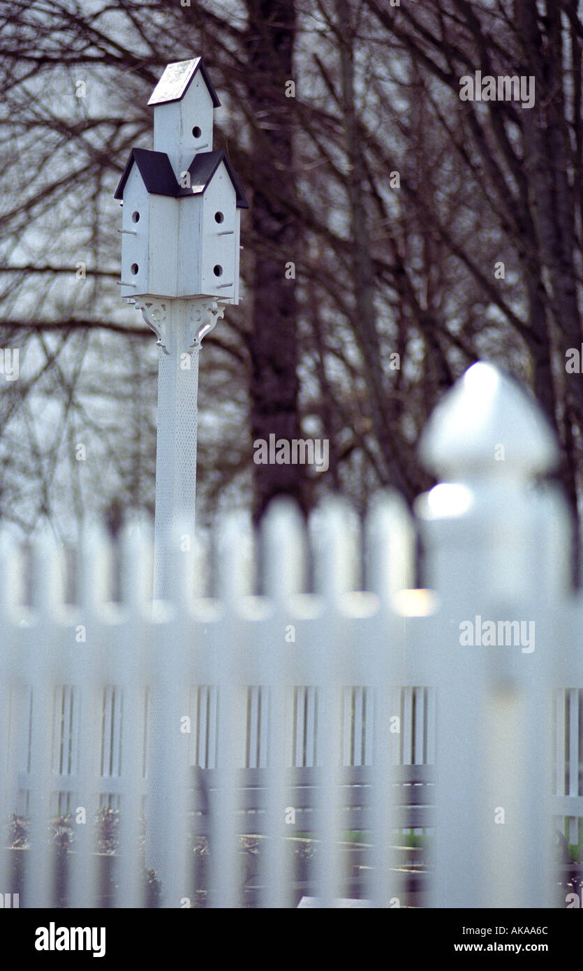 Birdhouse multilivello con white Picket Fence in primo piano Foto Stock