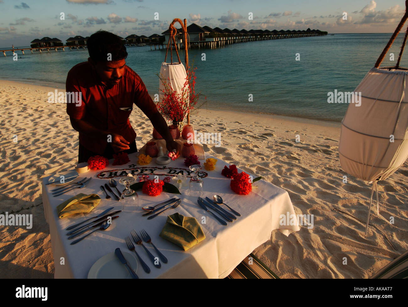 Maldive cameriere è che stabilisce la tabella per una romantica cena presso il Sun Island Resort Foto Stock